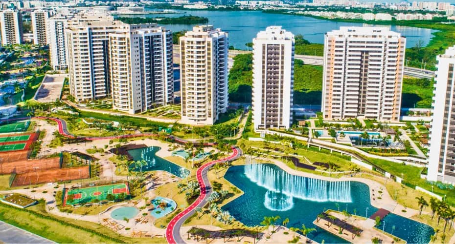 Como é a Vida no Ilha Pura? Esporte, Convivência e Qualidade de Vida 3 Vista aérea do Ilha Pura na Barra da Tijuca com lago, quadras esportivas, áreas de lazer e condomínios residenciais.